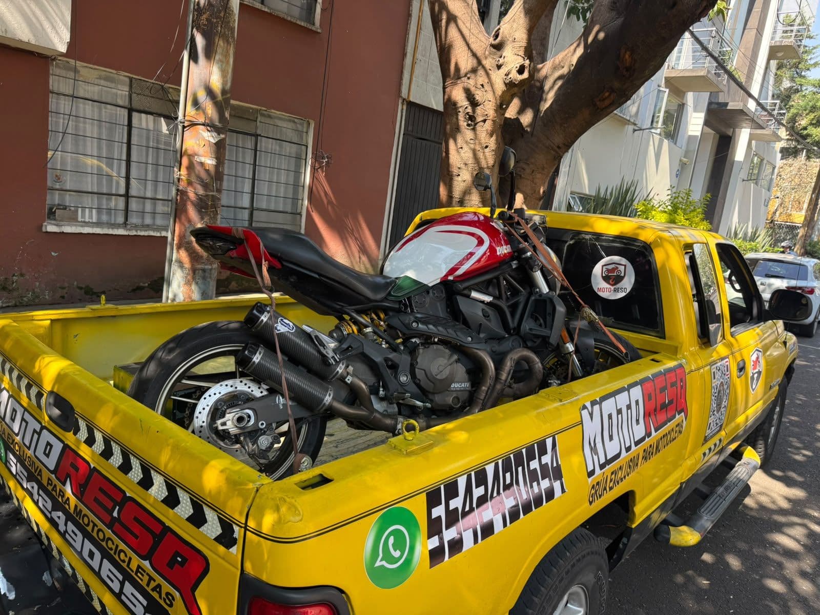 Motocicleta naked roja y negra cargada en la grúa de Moto-ResQ