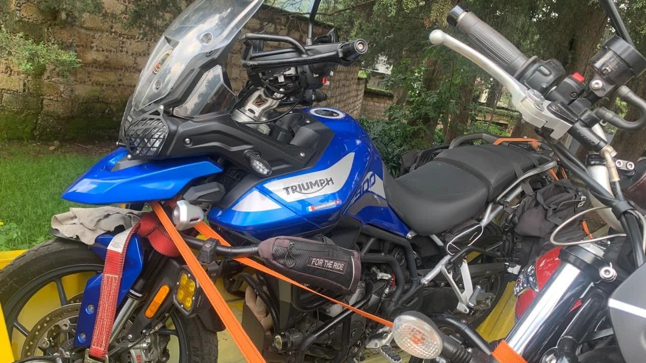 Motocicleta Triumph Tiger azul sujeta con correas naranjas