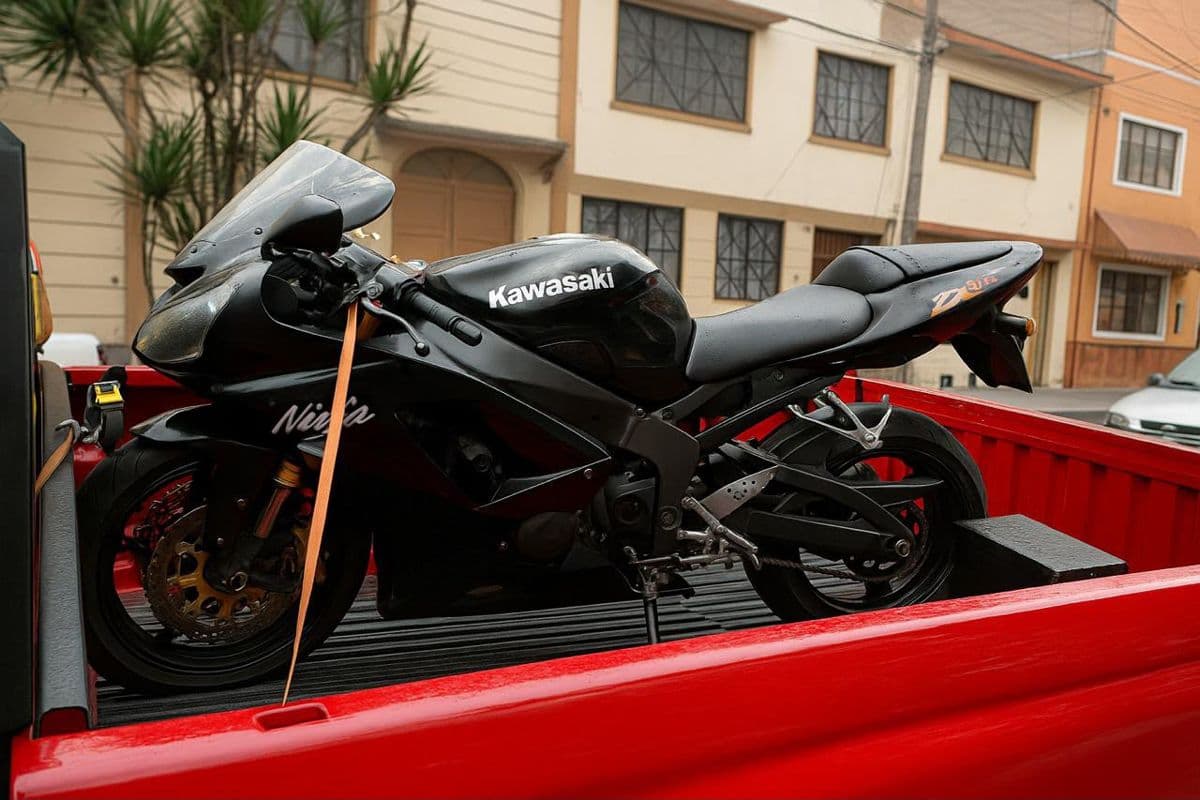Motocicleta Kawasaki Ninja asegurada con correas para su traslado